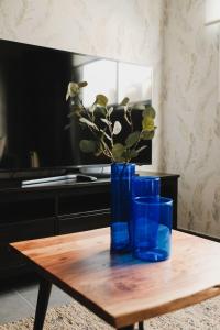 a blue vase with flowers on a wooden table at Apartamento de La Candelaria II in Santa Cruz de Tenerife