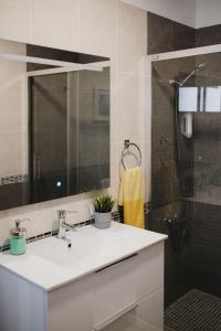 a bathroom with a sink and a shower with a mirror at Apartamento de La Candelaria II in Santa Cruz de Tenerife