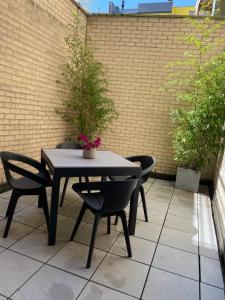 a table and chairs with a plant on a patio at Hotel Princess in Ostend