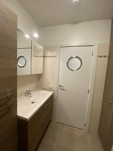 a bathroom with a sink and a door with two mirrors at Hotel Princess in Ostend