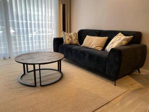 - un canapé noir avec une table dans le salon dans l'établissement Hotel Princess, à Ostende