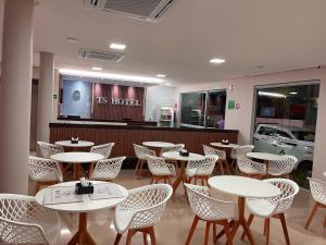 un restaurante con mesas y sillas frente a una tienda en TS HOTEL, en Porteirinha