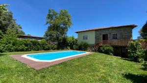 a swimming pool in the yard of a house at Casa de São Vicente de Cima in Póvoa de Lanhoso