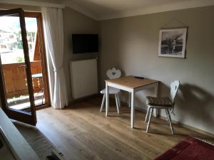 une chambre avec une table, des chaises et une fenêtre dans l'établissement Appartement Kitzsteinhorn, à Zell am See