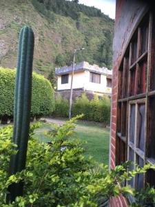 a house with a fence and a building behind it at Great Hostels in Baños