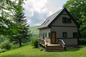 ein kleines weißes Haus mit einer Veranda und einer Treppe dorthin in der Unterkunft Green Mountain Paradise in Granville