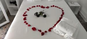 a heart made out of red roses on a bed at VACACIONES DUQUE GALEY in Punta Umbría
