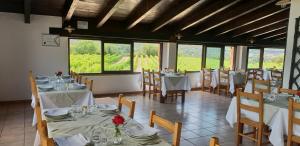 a dining room with tables and chairs and windows at Agriturismo Vermentino in Monti