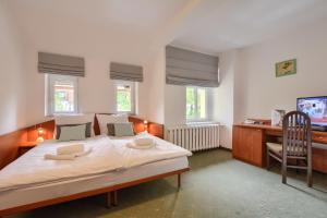 a bedroom with a bed and a desk with a computer at Hotel Kryształ in Świeradów-Zdrój +29 photos