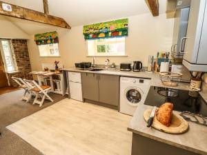 a large kitchen with a washer and dryer in it at The Old Mower Shed in Grantham