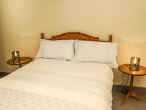 1 dormitorio con 1 cama y 2 mesitas de noche en The Old Mower Shed, en Grantham