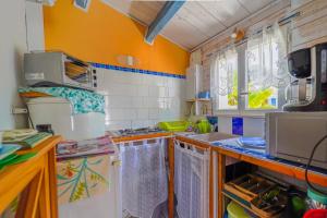 - une cuisine avec des murs orange et un réfrigérateur blanc dans l'établissement L'ILE D'YEU, vos prochaines vacances - Vélos et wifi gratuits, à Port-Joinville