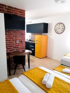um quarto com uma cozinha com uma mesa e um relógio em Evita Studio Apartment em Karlovac