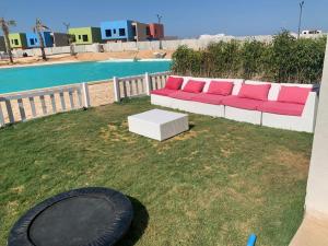 a couch sitting in the grass next to a pool at Bo Islands villa in El Alamein