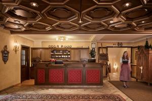 a woman standing in front of a bar in a room at Hotel Table in Corvara in Badia