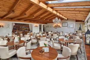un ristorante con soffitti e tavoli in legno e sedie di Hotel Table a Corvara in Badia
