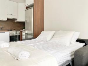 a white bed in a kitchen with towels on it at Tammer Huoneistot - City Suite 2 - City View & Perfect location in Tampere