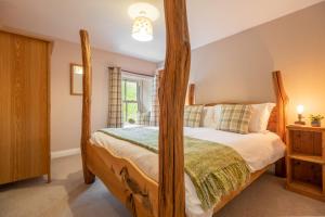 a bedroom with a wooden four poster bed at West Shaw Cote Cottage in Leyburn