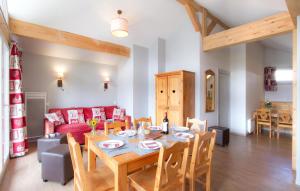 a living room with a table and a red couch at Résidence Odalys L'Ours Blanc in Les Deux Alpes