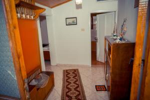 a living room with a kitchen and a hallway at Flora's Guesthouse 'The Fir Gate' in Gjirokastër