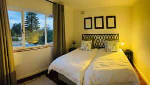 a bedroom with a large bed with a window at Villa Voigt in Hermanus