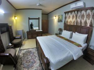 a bedroom with a large bed and a mirror at Seaview Guest House in Karachi