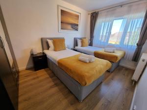 a hotel room with two beds and a window at 168 - ExcellentStays - 2 Bedroom Flat in Stanwell