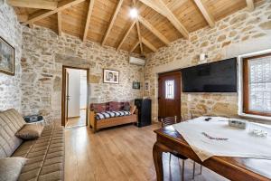 a living room with a stone wall and a couch at GUEST HOUSE APHRODITE in Káto Arkhánai