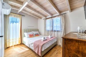 een slaapkamer met een bed en een groot raam bij GUEST HOUSE APHRODITE in Káto Arkhánai