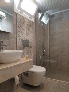 Un baño con inodoro, lavabo y ducha. en Limon Pansiyon, en Kas