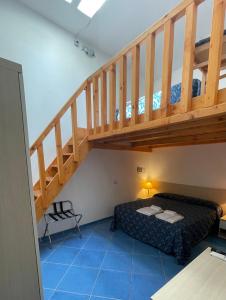1 dormitorio con 1 cama bajo una escalera de madera en B&B La Terrazza Sul Porto, en Ponza