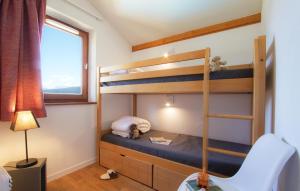 a small bedroom with bunk beds and a chair at Résidence Odalys Le Buet in Morillon