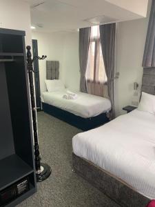 
a hotel room with two beds and a television at Trivelles Regency, Nottingham in Nottingham
