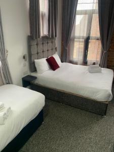 duas camas num quarto de hotel com uma janela em Trivelles Regency, Nottingham em Nottingham