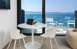 a white table and chairs with a laptop on it at Gallery Luxury Suites & Rooms-Only Adults in Split