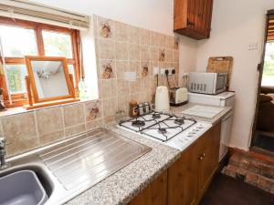 uma cozinha com um lavatório e um fogão em Woldsend Cottage em Horncastle