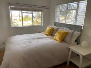 ein Schlafzimmer mit einem großen Bett mit gelben Kissen in der Unterkunft Warwick House - Stunning house with terrace and sea views, sleeps 11 in Worthing