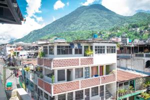 a view of a building with a mountain in the background at Hostal Corazón de San Pedro in San Pedro La Laguna