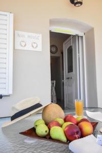 une assiette de fruits sur une table avec un verre de jus d'orange dans l'établissement Private House Niki Kalymnos, à Panormos Kalymnos