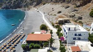 a view of a beach with buildings and the ocean at Agia Roumeli Hotel in Agia Roumeli