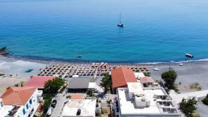 an aerial view of a beach with chairs and a boat at Agia Roumeli Hotel in Agia Roumeli