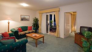 - un salon avec un canapé et une télévision dans l'établissement Royal Woods Resort, à Gold Coast