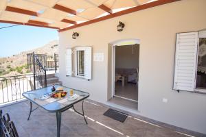 a view from the balcony of a house with a glass table at Private House Niki Kalymnos in Panormos Kalymnos