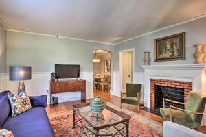 uma sala de estar com um sofá e uma lareira em Historic Augusta Cottage with Mid Century Vibe! em Augusta
