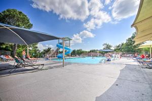 ベラ・ビスタにあるBella Vista Home with Deck and Trails On Golf Course!の椅子とパラソルが備わるプールを併設しています。