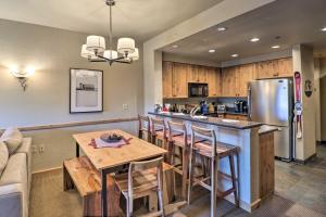 a kitchen with a table and a kitchen with a refrigerator at Ski-InandSki-Out Whitefish Escape with Balcony! in Whitefish