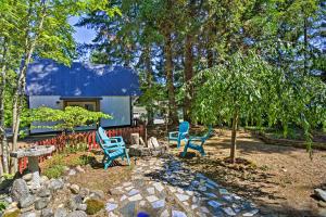 Quaint Lake Cushman Cottage with Private Access! في Hoodsport: زوج من الكراسي الزرقاء يجلس في الفناء