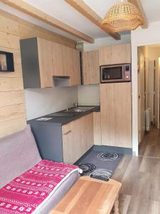 eine Küche mit Herd und Arbeitsplatte in der Unterkunft appartement cosy central et fonctionnel La Foux d'Allos in Allos