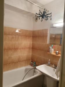 ein Badezimmer mit Badewanne und Waschbecken in der Unterkunft appartement cosy central et fonctionnel La Foux d'Allos in Allos