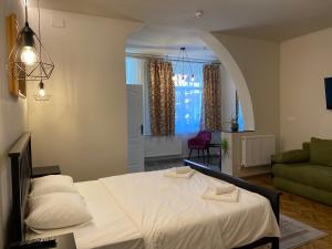 奥拉迪亚Boutique Rooms with Parking的卧室配有白色的床和绿色沙发
